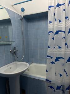 baño con lavabo y cortina de ducha con delfines en Квартира в Бишкеке, en Bishkek