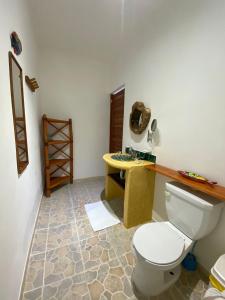 a bathroom with a white toilet and a table at Casa Pascale in Punta Allen