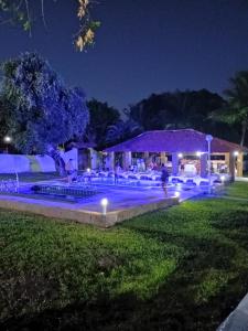 a swimming pool at night with lights in the grass at Pousada Villa do Mar in Itaparica Town