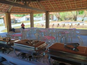 a row of tables and chairs with trays on top at Pousada Villa do Mar in Itaparica Town
