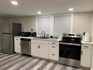 a kitchen with a stove and a sink and a refrigerator at Newly Renovated Lincolnton Downtown Rail Trail Apartment - Walk to Main St in Lincolnton