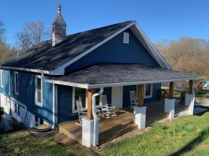 una casa blu con un portico con sedie sopra di Newly Renovated Lincolnton Downtown Rail Trail Apartment - Walk to Main St a Lincolnton