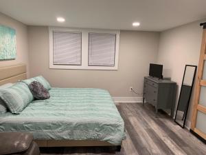 a bedroom with a bed and a dresser with a television at Newly Renovated Lincolnton Downtown Rail Trail Apartment - Walk to Main St in Lincolnton