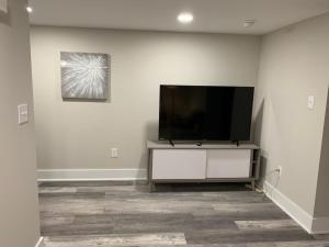 un soggiorno con TV a schermo piatto su una parete bianca di Newly Renovated Lincolnton Downtown Rail Trail Apartment - Walk to Main St a Lincolnton