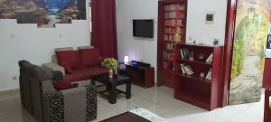 a living room with a couch and a tv at Agreable Studio Meuble in Abidjan