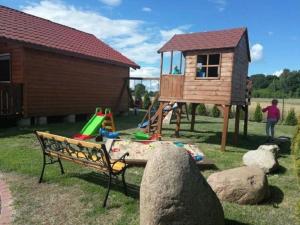 a playground with a tree house and a bench at Ferienhaus in Rusinowo mit Großer Terrasse - b54244 in Rusinowo