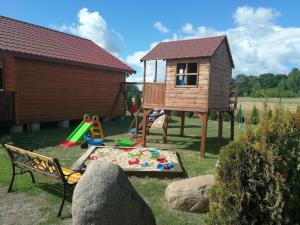 a childrens play area with a house and a playground at Ferienhaus in Rusinowo mit Großer Terrasse - b54244 in Rusinowo