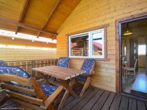 a wooden deck with a wooden table and chairs at Ferienhaus in Rusinowo mit Großer Terrasse - b54244 in Rusinowo