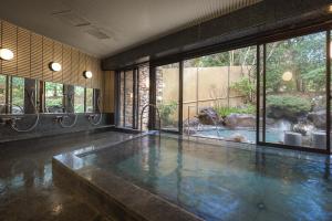 a room with a swimming pool with a large window at nol hakone myojindai in Hakone