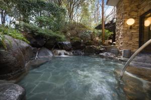 una piscina de agua con una cascada en un patio en nol hakone myojindai, en Hakone