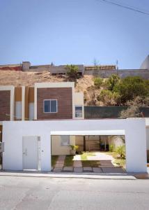 a white house with an archway in the street at Agradable Casa Madeira Tijuana Rosarito in Tijuana