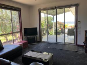 a living room with a couch and a tv and sliding glass doors at Eagle Bay Views in Eagle Point