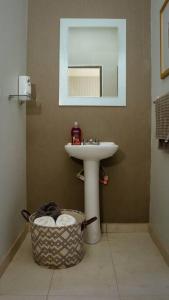 a bathroom with a sink and a basket of towels at Agradable Casa Madeira Tijuana Rosarito in Tijuana