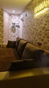 a living room with a couch and a brick wall at Hannah in Krāslava