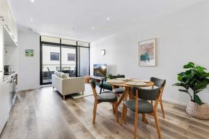 a living room with a dining room table and chairs at Tasteful 2-Bed Unit By Bridge Rd Shops in Melbourne
