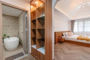 a bathroom with a bed and a bath tub next to a bedroom at Villa Abigail Chiang Mai in Chiang Mai
