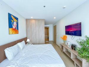 - une chambre avec un grand lit blanc et une télévision dans l'établissement CĂN HỘ 5 SAO THE SÓNG VŨNG TÀU Mr VƯƠNG, à Vung Tau