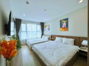 Cette chambre comprend deux lits et une télévision. dans l'établissement CĂN HỘ 5 SAO THE SÓNG VŨNG TÀU Mr VƯƠNG, à Vung Tau