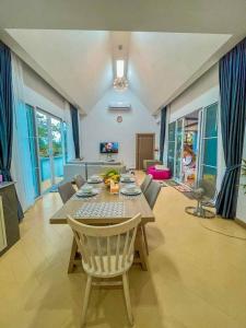 a dining room with a table and chairs in a room at Pool Villa Udonthani in Udon Thani