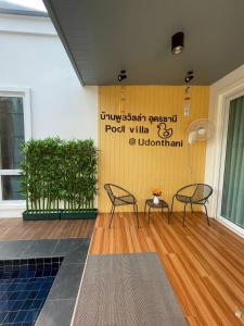une chambre avec deux chaises et un mur jaune dans l'établissement Pool Villa Udonthani, à Udon Thani