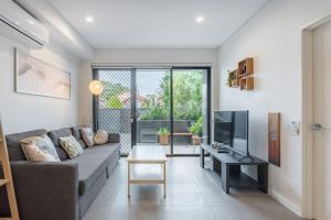 Una sala de estar con un sofá y un televisor. en 1Bedroom and Study Apt in Homebush Sleeps 5, en Sídney