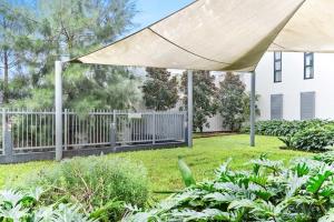 a patio with a white umbrella in a yard at New Modern 2BR 2baths Apt in Homebush Sleeps 6 in Sydney