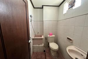 a bathroom with a toilet and a sink at HOTEL WARTA SARI in Denpasar