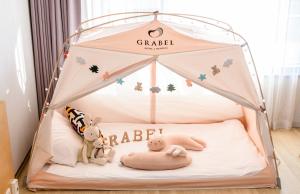 a childs bed with a tent in a room at Grabel Hotel Jeju in Jeju