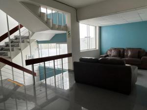 a living room with a couch and a staircase at Hotel Santa María in Piura