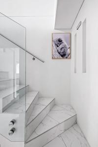 Baño blanco con escaleras y una foto en la pared en Lovely 4 Bedroom 3 Bathroom Modern Home Sleeps 8 en Revesby