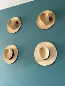 a group of straw hats on a blue wall at Hotel Santa María in Piura
