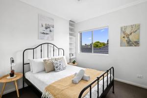 1 dormitorio con cama y ventana en Lovely 4 Bedroom 3 Bathroom Modern Home Sleeps 8 en Revesby