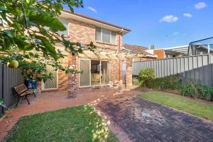 a brick house with a fence and a yard at 3 Bdrms Duplex in Greystanes in Merrylands