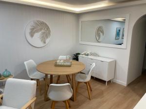 a dining room with a table and white chairs at Pelican Cove Apartments in Gold Coast