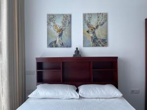 a bedroom with two paintings of deer on the wall at Peak of Colombo in Colombo