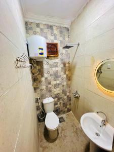a small bathroom with a toilet and a sink at King pyramids view inn in Cairo