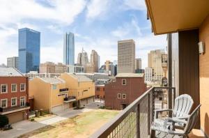 a balcony with a chair and a view of a city at Rustic Paradise In Downtown OKC. in Oklahoma City