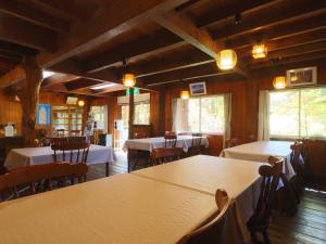a dining room with tables and chairs and windows at 雀の宿 やぐら in Matsumoto