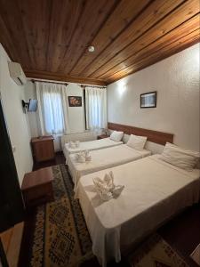 pokój z 2 łóżkami i kwiatami w obiekcie Akay Hotel w mieście Selçuk