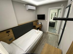 a small room with a bed and a television at Comfort Center Suit Hotel in Edirne