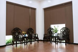 een eetkamer met stoelen en een tafel en ramen bij Bảo Hưng Hotel in Thanh Hóa