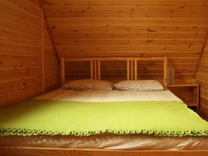 a bedroom with a bed in a log cabin at Modernes Ferienhaus in Kopalino mit Grill, Garten und Terrasse in Kopalino