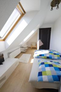 a attic bedroom with two beds and a window at Appartement in Naterki mit Terrasse, Garten und Grill in Naterki