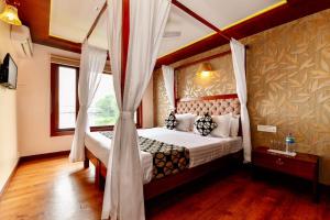 a bedroom with a canopy bed and a window at Luxury Houseboat in Alleppey