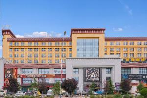 ein großes gelbes Gebäude mit vielen Fenstern in der Unterkunft Mehood Theater Hotel, Lhasa in Lhasa