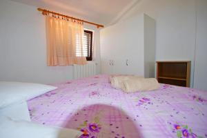 Un dormitorio con una gran cama rosa con flores. en Ferienwohnung "Cherry" mit Meerblick, en Banjole
