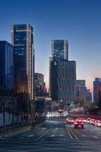 une ligne d'horizon avec des voitures dans une rue de la ville la nuit dans l'établissement Grand Barony Jinan CBD, à Jinan