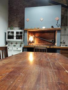 una gran mesa de madera en una cocina con chimenea en Arenales Centro en Chascomús