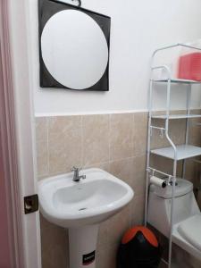 W łazience znajduje się umywalka, lustro i toaleta. w obiekcie Figueroa's House. w mieście Santa Ana