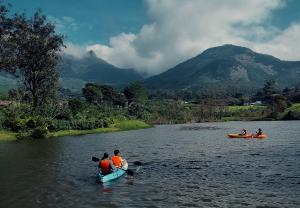 a group of people in kayaks on a river at Campper Campwoody Munnar in Munnar
